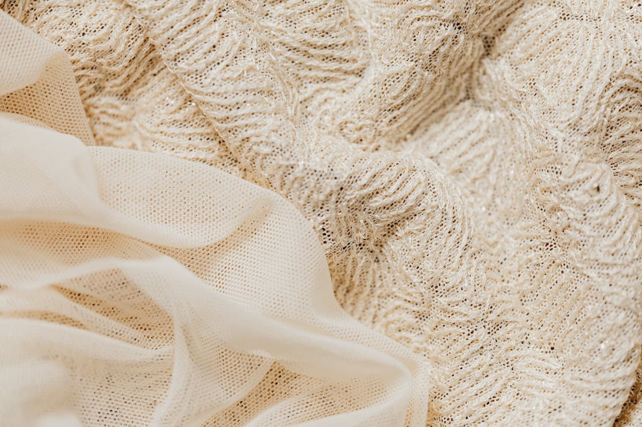 Close-up view of intricate beige lace fabric and sheer material, ideal for fashion and textile projects.